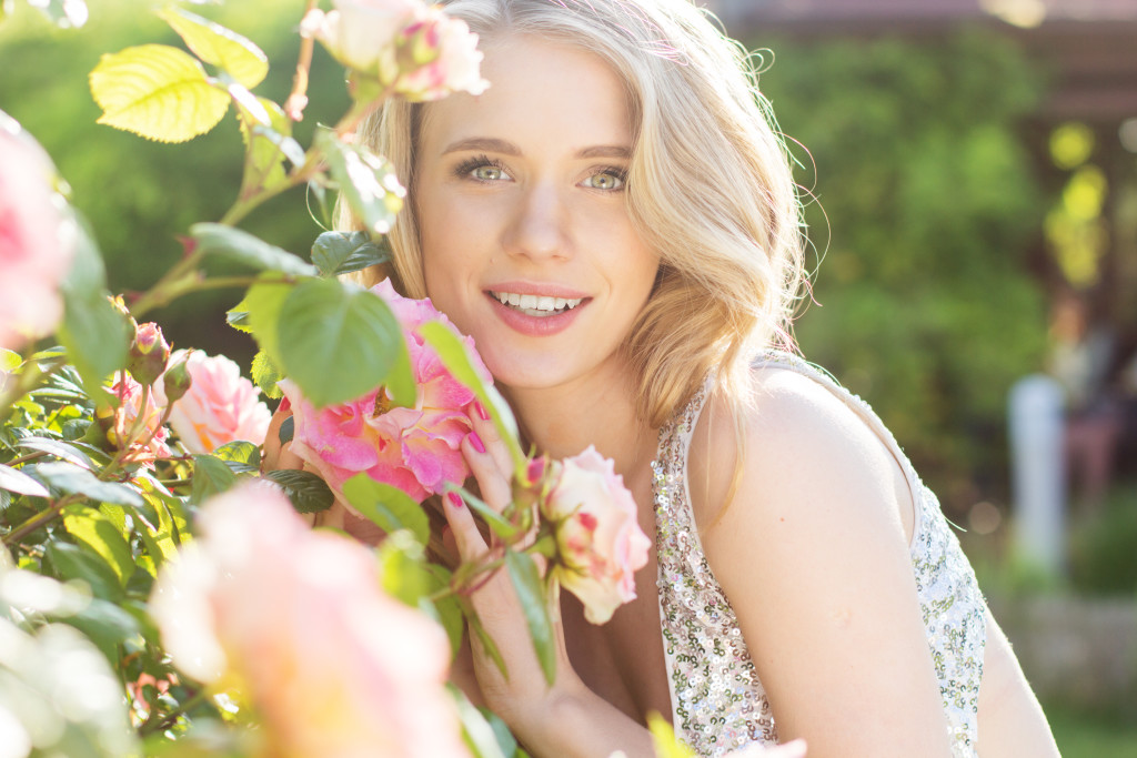 Portrait of fashion beauty model girl with flowers of pink roses