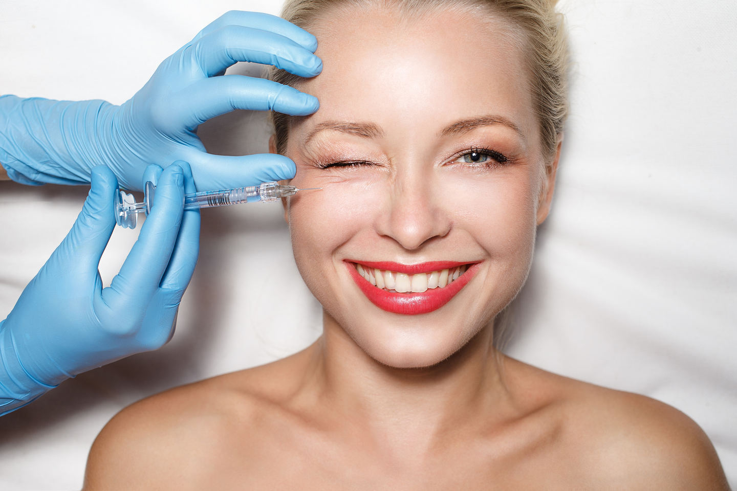 Attractive woman at plastic surgery with syringe in her face