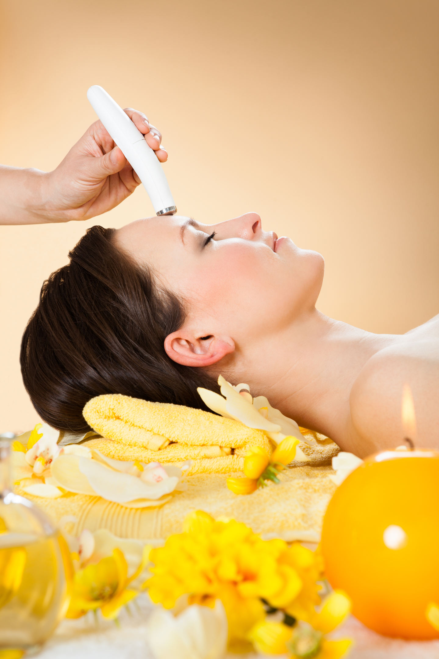 Side view of woman receiving microdermabrasion therapy on forehead at beauty spa