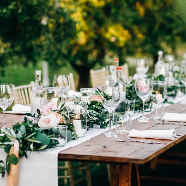 Floral garland of eucalyptus and pink flowers lies on the table